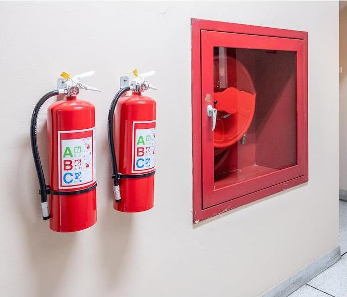 img src =”extinguisher” alt = "two fire extinguisher hanging on a tan interior wall  ” >